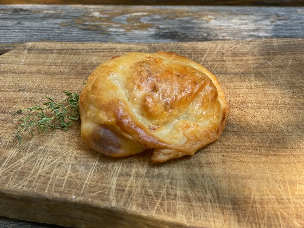 Käse-Empanada im Schnitt, mit geschmolzenem Käse und Frühlingszwiebeln