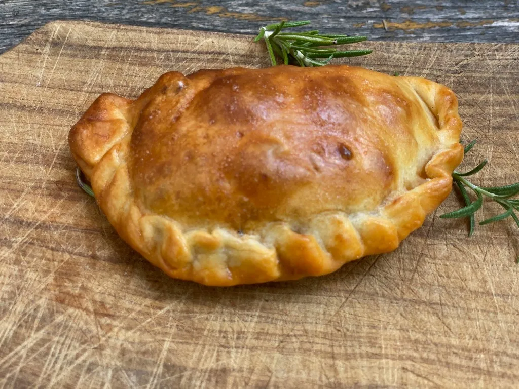 Rindfleisch-Empanada, goldbraun gebacken und mit Repulgue verschlossen