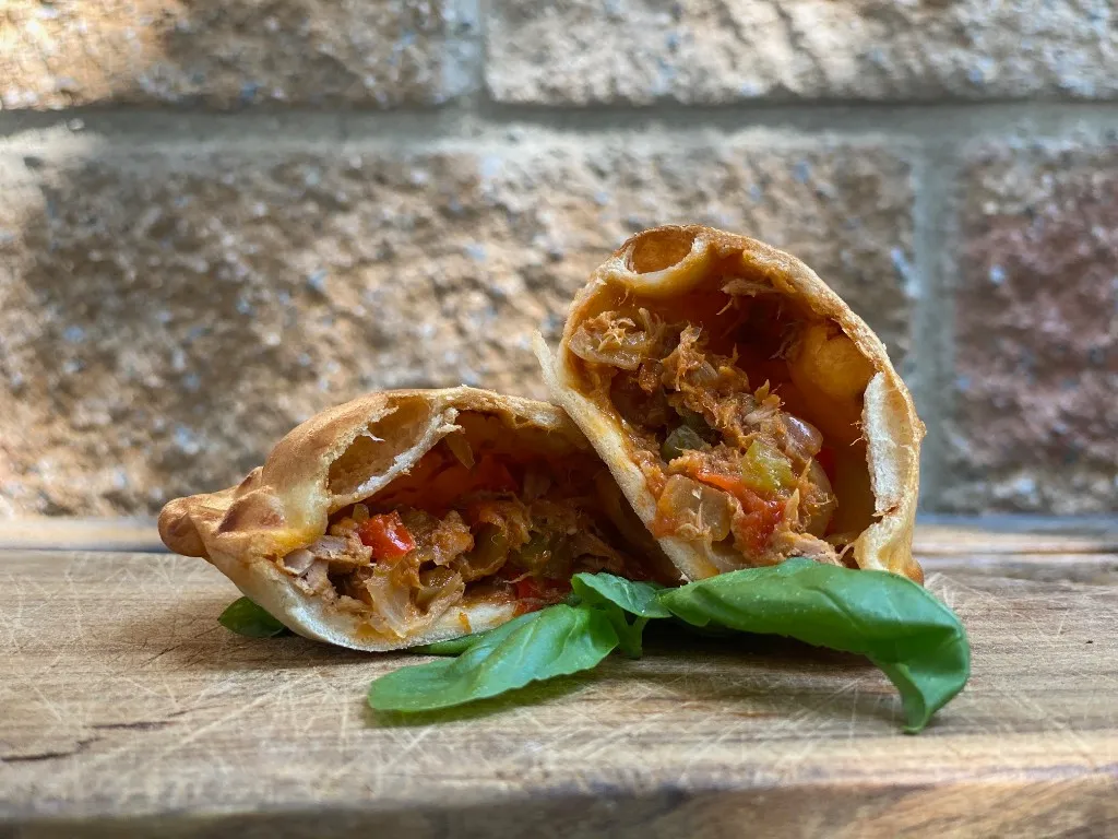 Thunfisch-Empanada, goldbraun gebacken und mit Repulgue verschlossen